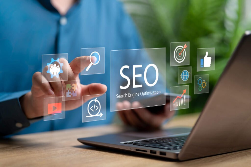 Une personne devant un ordianteur portable avec sa main qui touche une icone avec l'inscription SEO.